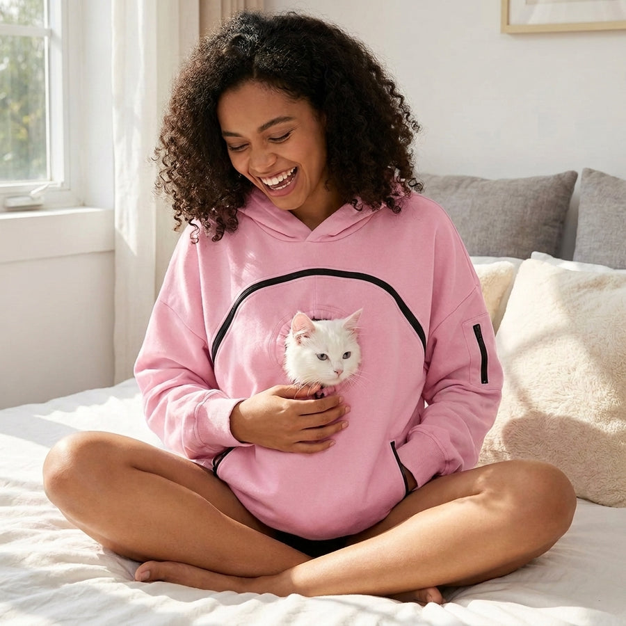 Woman in the pink Mewdie hoodie with a white cat peeking out